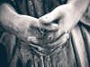 A close-up of the weather worn hands of a angel statue