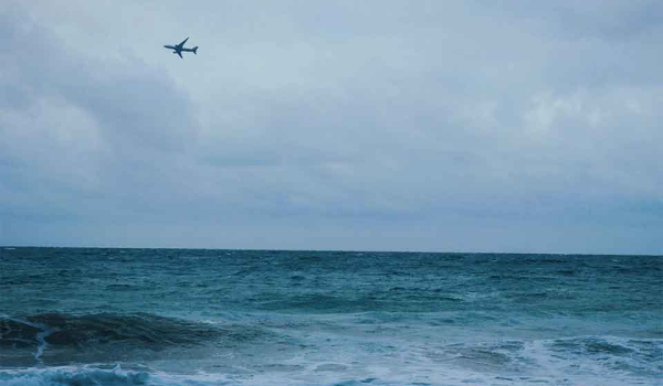 A stormy sea churning beneath a grey-blue, cloud-choked sky
