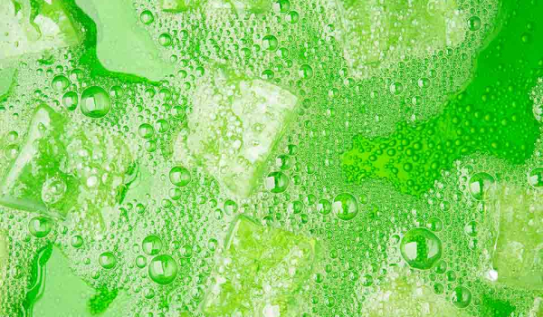 Ice-cubes floating in a fizzy green liquid