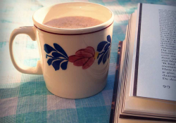 Cup of coffee next to a book