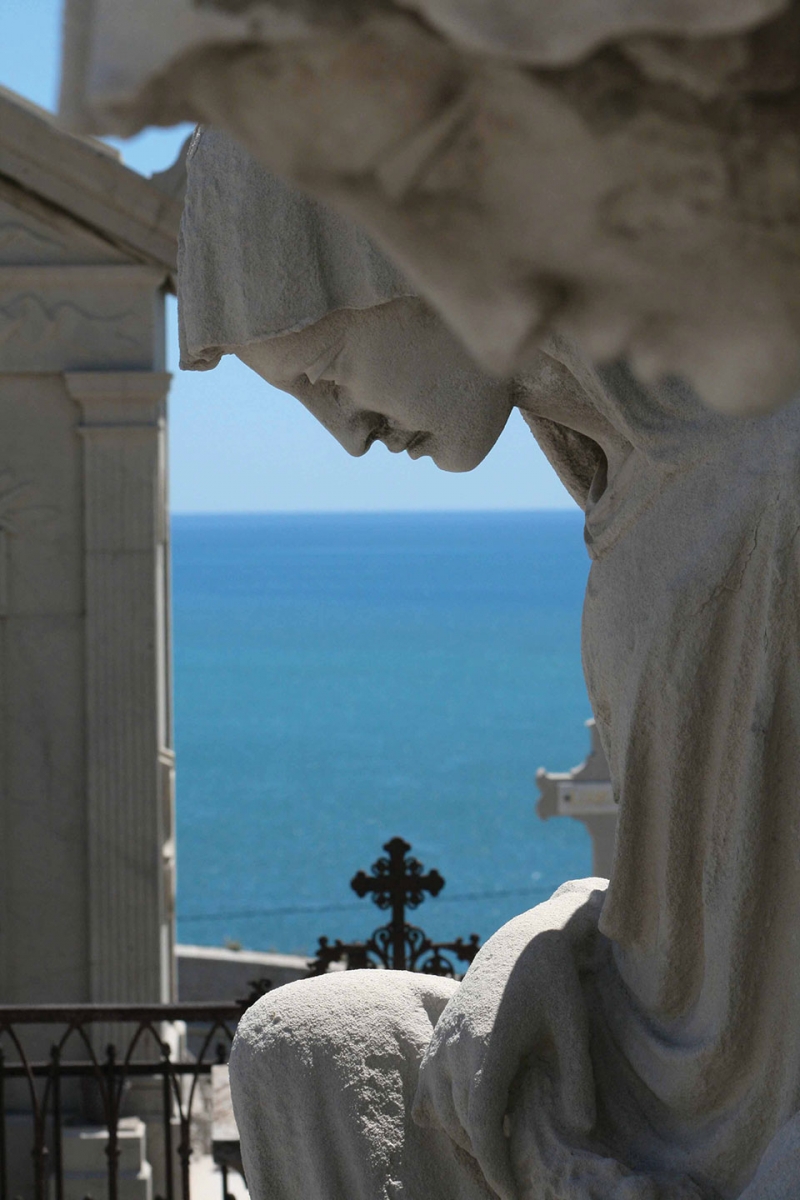 A statuary in the extreme foreground with the sea in the deep background.