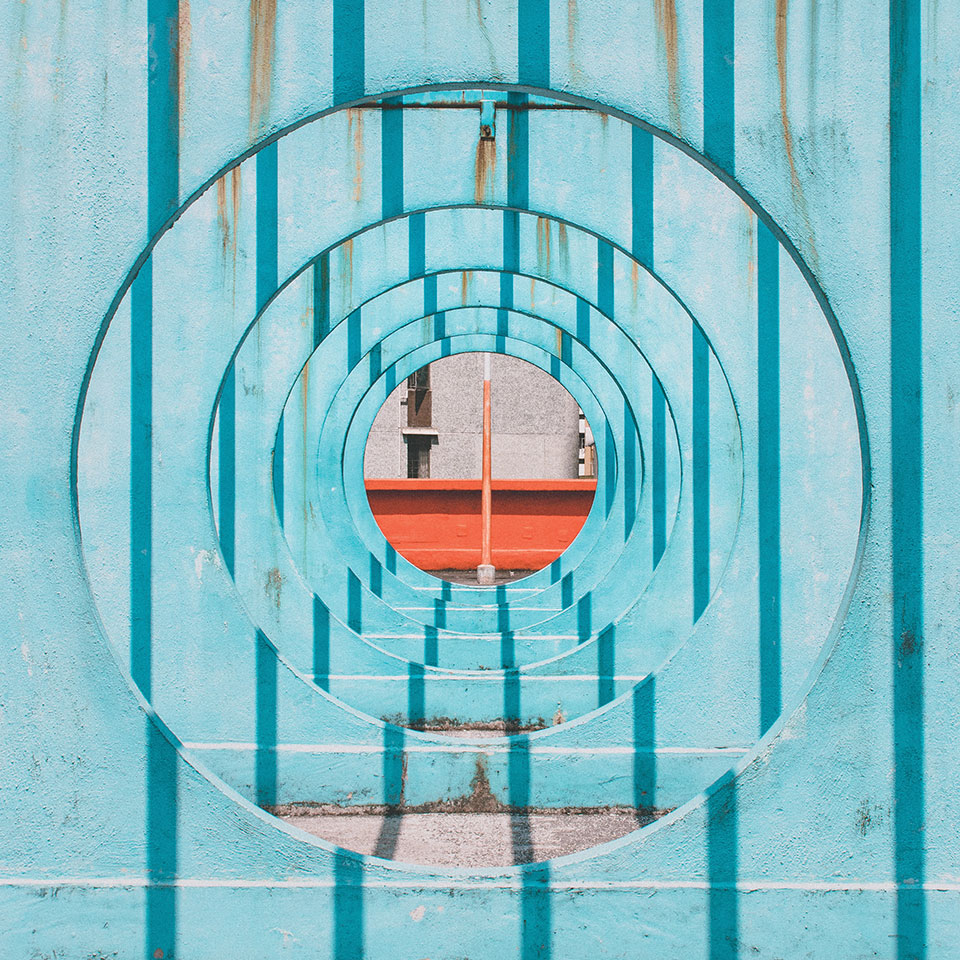 Looking through a series of blue gates, each with a hole in the center. A red crossbeam can be seen just beyond the final wall.