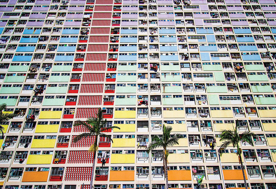 A photograph looking up the front of a colorful apartment building