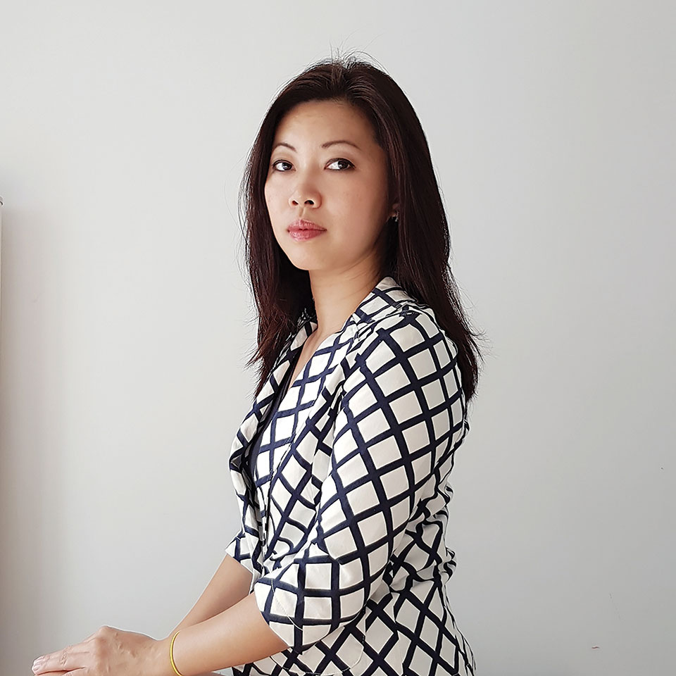 Grace Chia sits against a white background, looking at the camera