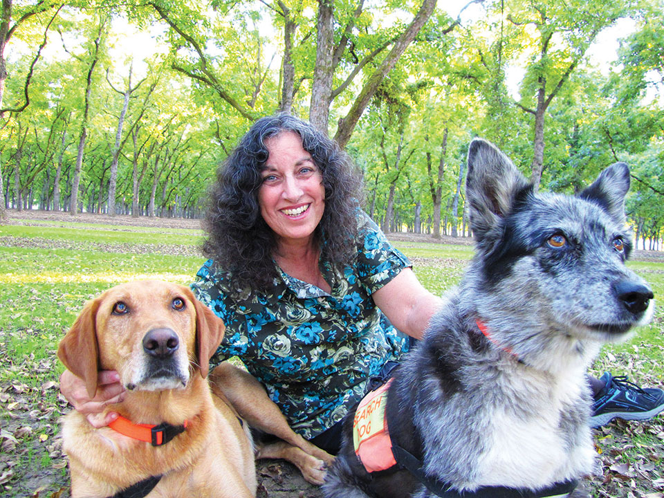 Margarita reposes in a pecan grove with two dogs