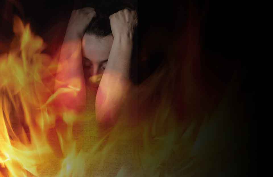 A photo collage of a human figure in emotional distress with fire superimposed over them