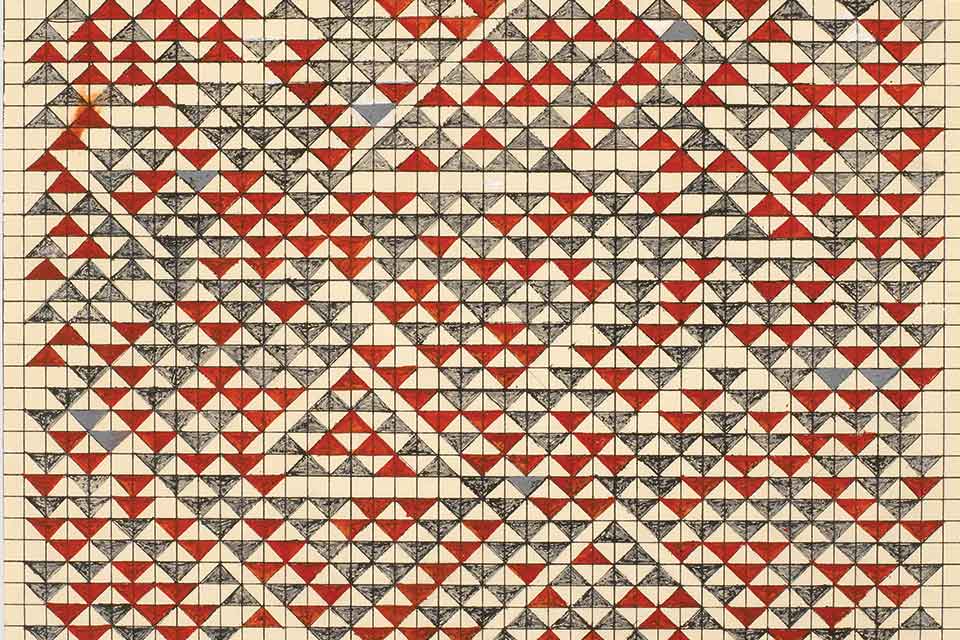 A photograph of a textile piece by Anni Albers. Small beige, red, and white triangles on a beige background