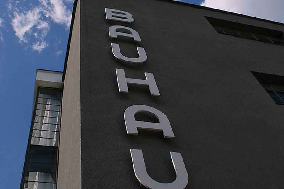A photograph of the famed Bauhaus building. Shot looking up at the Bauhaus sign, the letters stacked vertically.