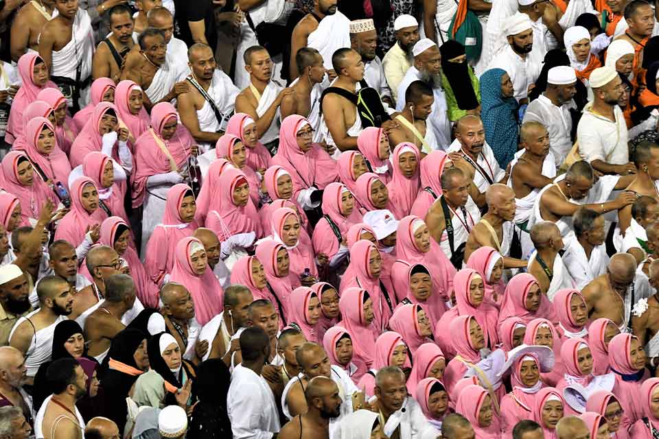 A small phalanx of women garbed in pink move among a crowd of men