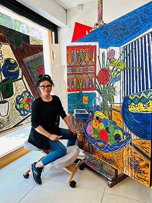 A photograph of Mustafa Faya in her studio surrounded by her work