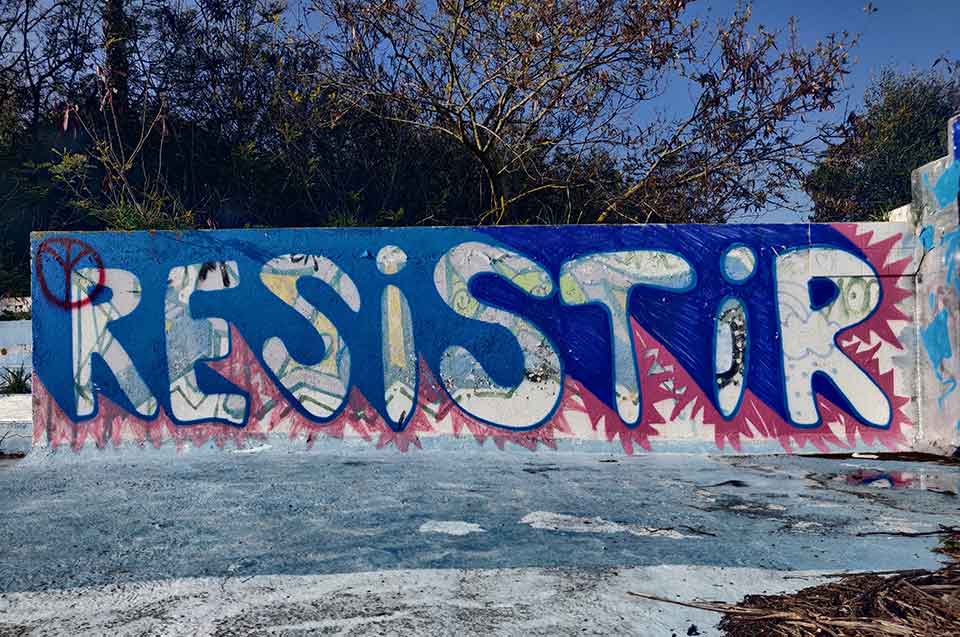 A photograph of a painted sign that reads Resist