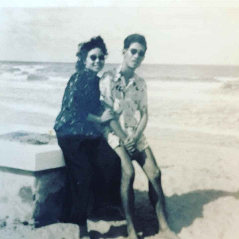 A black and white photograph of Lam's mother and father sitting together on a beach