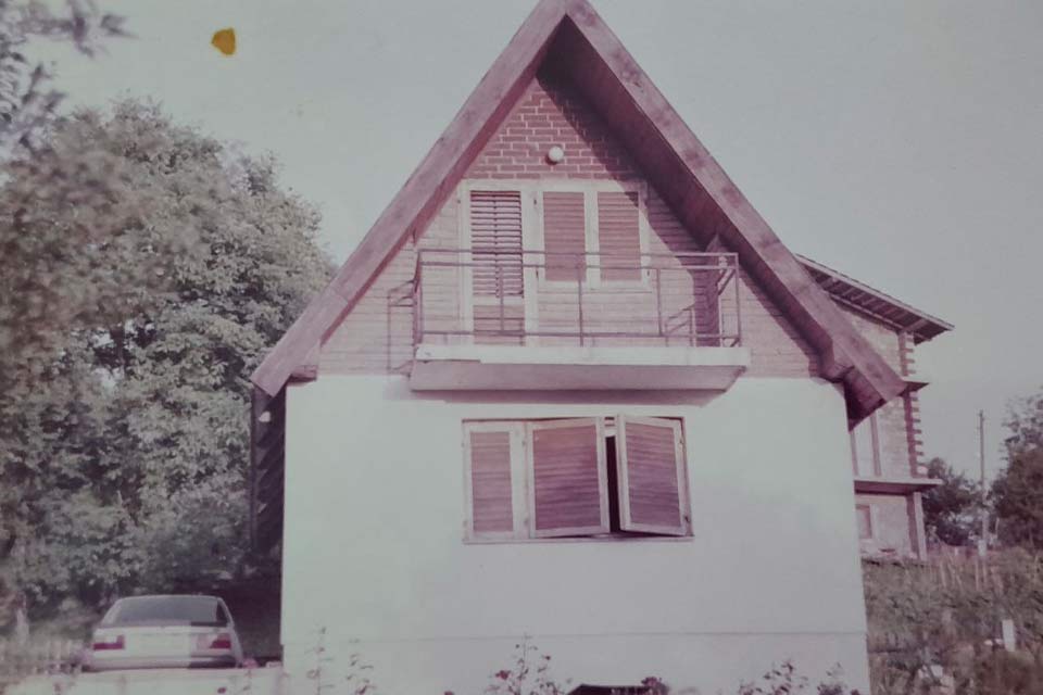 A faded color photograph of an old farm house