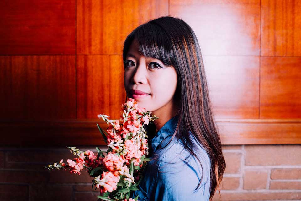 A photograph of Jane Wong holding a bouquet of flowers