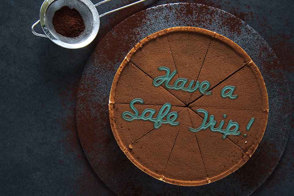 A chocolate pie with the words Have a Safe Trip written on it in frosting