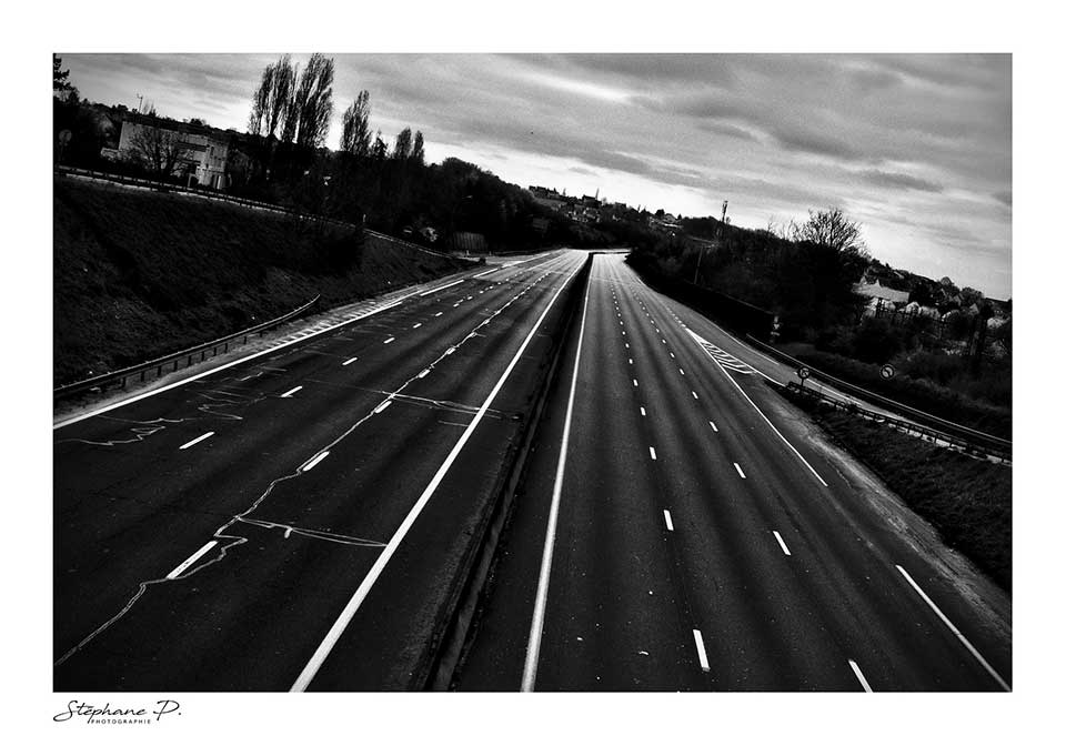 A black and white photograph of an deserted urban highway