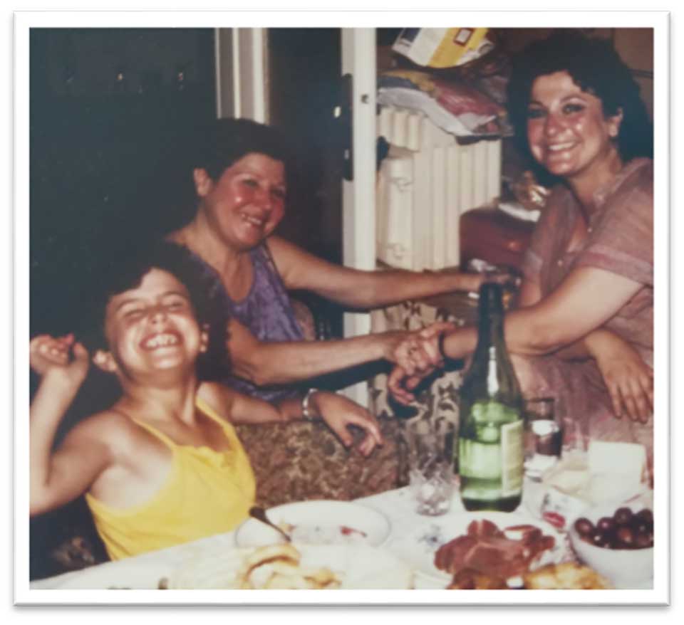 An older color photograph of people celebrating at a table