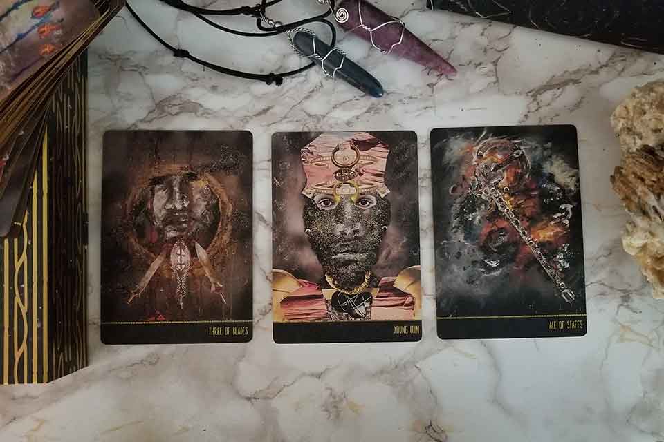 A photograph of three tarot cards laid out on a marble table top