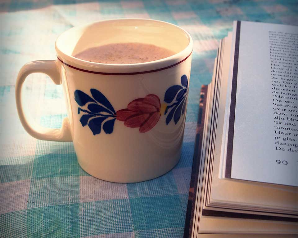 Cup of coffee next to a book