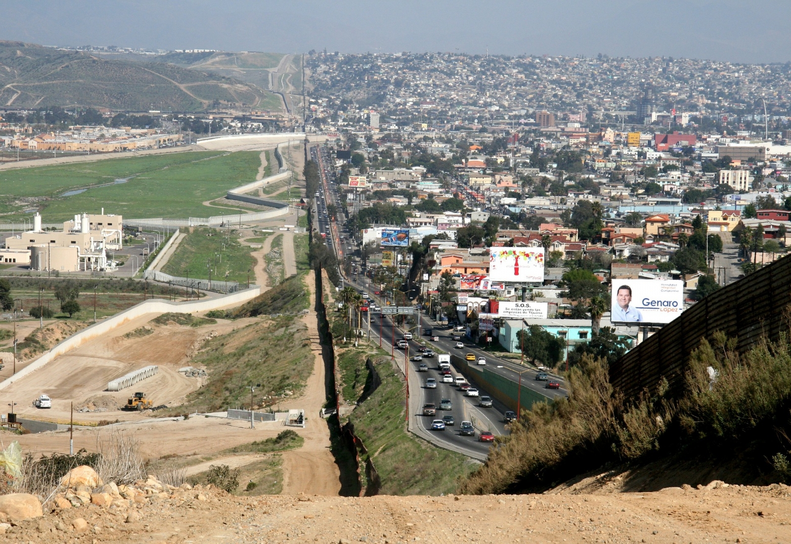 A photo of the border between the United States and Mexico showing sparse population on the US side and signs of high density populations on the Mexican side