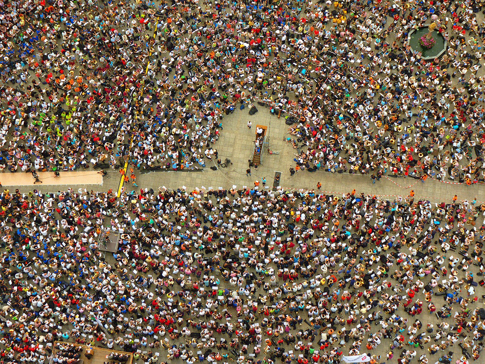 A photo shot from overhead of a crowd gathered in a square for a protest.