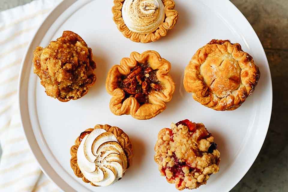 A photograph of six pastries on a white serving platter from above