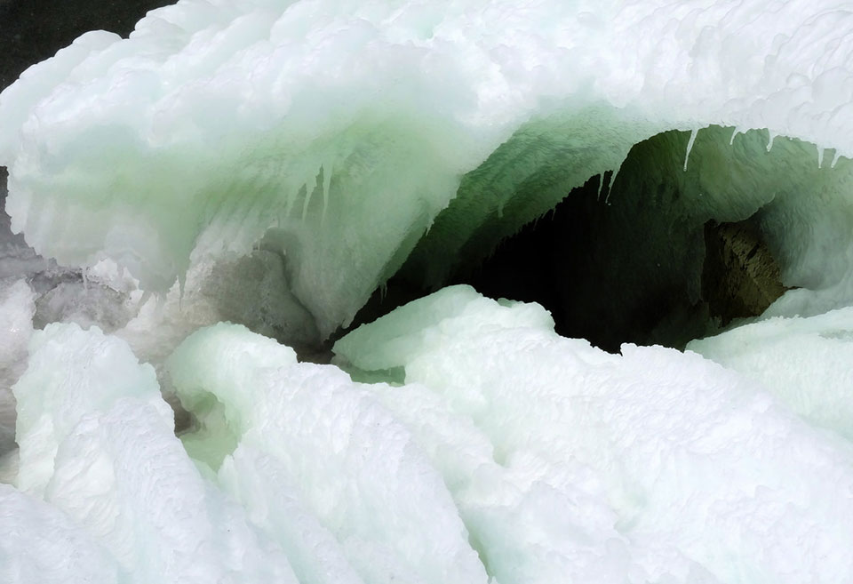 Thick sheets of ice warp to reveal a dark hole within