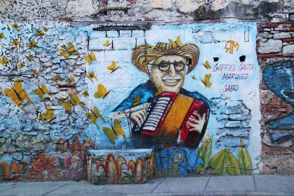 A photograph of a mural depicting a cartoonish drawing of Gabriel Garcia Marquez playing an accordion