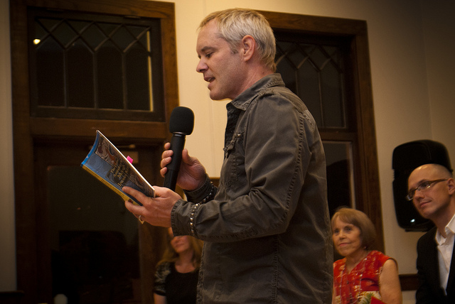 Nathan Brown reading a poem at opening night. Photo by Nicole  Drapeau.