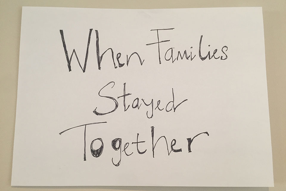A hand-written sign. Text reads: When families stayed together.