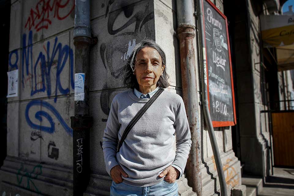 A photograph of Elvira Hernández standing in an urban landscape