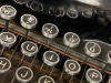 A close-up photograph of the punctuation/number row of a manual typewriter