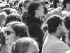 A black and white photo of a crowd with a figure at its center who is blurred