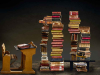 A photo of an antique student desk facing several stylishly designed stacks of books