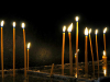 Thin, tapered, and lit candles arising from water
