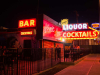 A desultory looking bar, decked with neon signs, presumably in Las Vegas