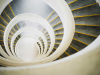 A photograph of a downwardly spiraling staircase, shot from above