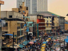 A photograph of a busy city street in Lagos with the skyline rising the background
