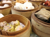 Small dishes of food in bamboo bowls on a dim sum cart