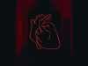 The red neon outline of a heart sits on a black background with crimson frames surrounding the heart