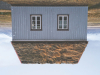A photograph of an upside-down house with a cultivated sod roof 