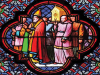A stained glass image of robed figures in ecclesiastical garb