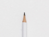 The tip of a white pencil laying on a piece of white paper
