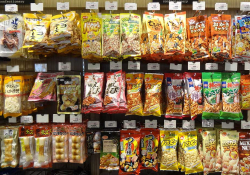 Packaged foods hang uniformly from wall pegs in a Japanese convenience store