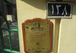 A photograph of a Arabic-language marker that sits on the exterior of a building in Egypt
