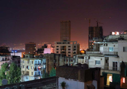 A photograph looking over the roof line at the city of Beirut at night