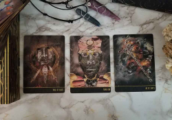 A photograph of three tarot cards laid out on a marble table top