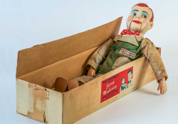 A ventriloquist's dummy in a cardboard box