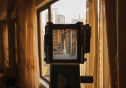 A camera is looking out a window at the city of Manilla. The image of the city is inverted in the camera's viewfinder.