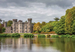 A castle swathed in forest sitting at water's edge